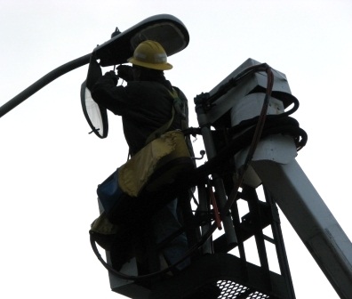 Streetlight Being Repaired by Worker in Lift
