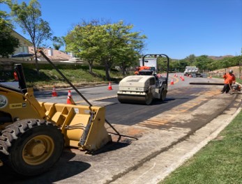 City Street Maintenance Employees Paving and Compacting Asphalt